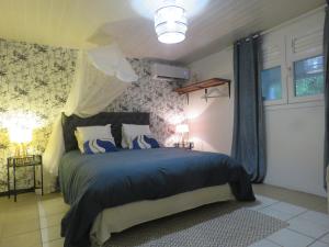 a bedroom with a bed with a blue comforter at Serenity in Gros-Morne