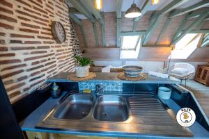 a kitchen with a sink and a brick wall at Charmant studio centre historique in Pau +15 photos