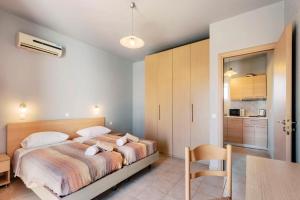 a bedroom with a bed and a table and a kitchen at F.D. Apartment in Lardos