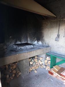 a grill with a green bench and logs at Apartment House Zdrelac - Meri in Ždrelac