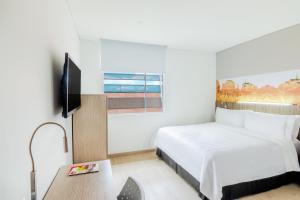 um quarto de hotel com uma cama e uma televisão em GHL Hotel Neiva em Neiva