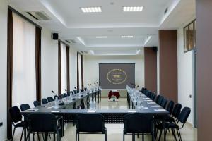 una sala de conferencias con una mesa larga y sillas en Ani Central Inn, en Ereván