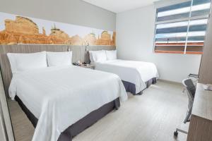 Ένα ή περισσότερα κρεβάτια σε δωμάτιο στο GHL Hotel Neiva