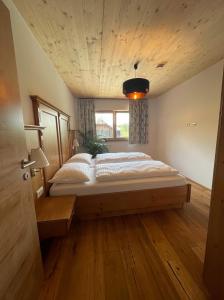 duże łóżko w pokoju z drewnianym sufitem w obiekcie Apartment Goaßa - Familie Zehner w mieście Göriach