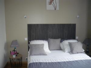 1 dormitorio con 1 cama grande y cabecero de madera en Gîte CLIMATISE les althéas, en Lanquais