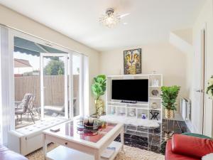 a living room with a tv and a table at Cheerful Townhouse in Sittingbourne