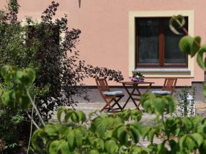 dwa krzesła i stół przed domem w obiekcie Fewo Blick zum Stern w mieście Wermsdorf