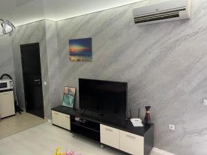 a living room with a flat screen tv on a wall at Менада Хоризонт Апартаменти in Sozopol