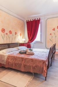 1 dormitorio con 1 cama grande y cortina roja en B&B Al Giardino dei Laghi, en Revine Lago