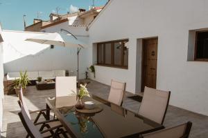 a patio with a table and chairs and an umbrella at El Retiro de la Adrada AVILA in La Adrada