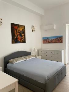 Un dormitorio con una cama y un cuadro en la pared. en Casa in piazzetta, en Balestrate
