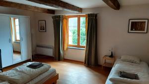 een kamer met 2 bedden en een groot raam bij Maison de Ninie in Rochefort