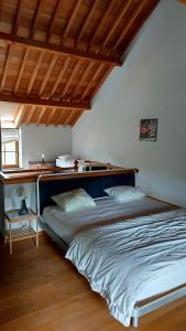 ein großes Bett in einem Schlafzimmer mit Holzdecke in der Unterkunft Maison de Ninie in Rochefort