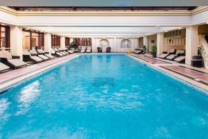 a large swimming pool with chairs in a hotel at Redworth Hall Hotel- Part of the Cairn Collection in Darlington