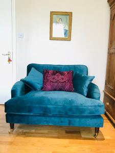 eine blaue Couch mit einem lila Kissen drauf in der Unterkunft Stunning Super King, Close to Beach, Shared Bathroom in St. Leonards