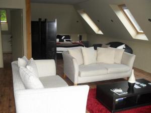 a living room with two white couches and a table at Cityescape in Kaimai