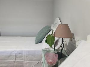 a glass table with a lamp next to a bed at Calleja La Pimentera in Córdoba