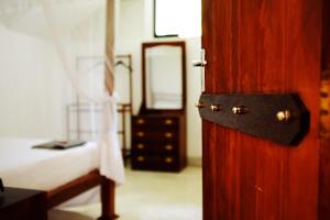 an open door to a bedroom with a bed and a mirror at Pedlar 62 Guest House in Galle