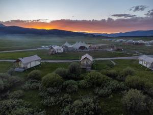 eine Luftansicht von Zelten auf einem Feld bei Sonnenuntergang in der Unterkunft Under Canvas West Yellowstone in West Yellowstone