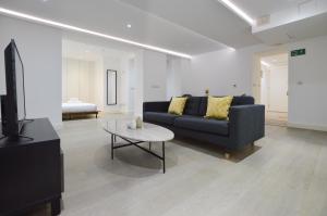 una sala de estar con un sofá y una mesa en Soho 22 Serviced Apartments by Concept Apartments, en Londres