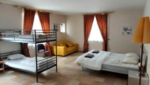 1 dormitorio con 2 literas y sofá en Grange de Ninie, en Rochefort