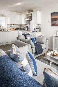 a living room with two couches and a kitchen at Seasalt Camber in Camber