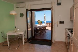a kitchen and dining room with a view of the ocean at SunnyHomeCefalù39 in Cefalù