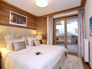 een slaapkamer met een groot wit bed en een raam bij Appartement Courchevel 1550, 5 pièces, 8 personnes - FR-1-664-4 in Courchevel