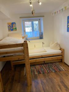 a bedroom with two bunk beds and a window at Familien-Appartement #10 Obermoosen in Übersee