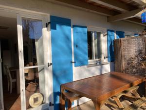 a porch with a wooden table next to a door at Familien-Appartement #10 Obermoosen in Übersee