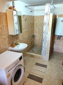 a bathroom with a shower and a washing machine at Casa Nautica in Jurilovca