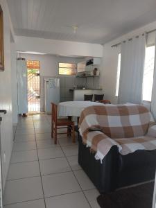 Sua casa no litoral في بارنايبا: غرفة معيشة مع طاولة ومطبخ