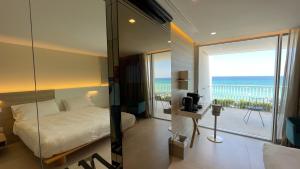 a bedroom with a bed and a view of the ocean at Posia Retreat & Spa UNA Esperienze in San Foca