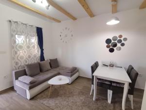 Guest House Dzakovic Stana في زبلجك: غرفة معيشة مع أريكة وطاولة