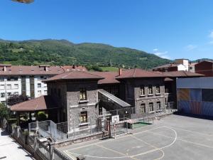 ein Gebäude mit einem Basketballplatz davor in der Unterkunft Apartamento Brañavalera in Pola de Lena
