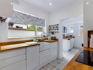 a kitchen with white cabinets and a window at Berrington17 in Woolton