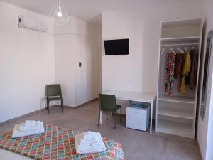 a bedroom with a bed and a desk and chairs at House Salento Central Rooms in Torre San Giovanni Ugento