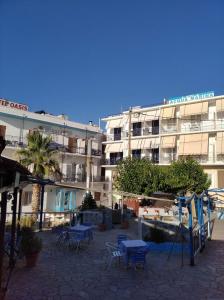 a building with tables and chairs in front of it at Ammoudia Rooms in Agia Marina Aegina