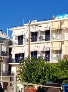 a white apartment building with a clock on it at Ammoudia Rooms in Agia Marina Aegina