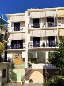 biały apartamentowiec z balkonami i drzewami w obiekcie Ammoudia Rooms w miejscowości Agia Marina