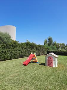 a playground with a slide and a play house at Villa Nina in Fontane Bianche