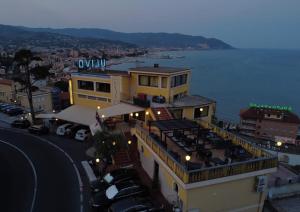 a building with a restaurant on top of it next to the water at Ulivo in Diano Marina