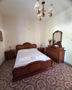 a bedroom with a bed and a dresser and a mirror at Tenuta Aquilae in Castrofilippo