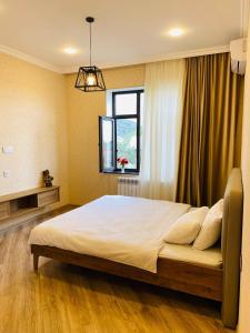 a bedroom with a large bed with a window at Qabala Lux Villa in Gabala