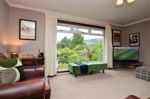 a living room with a large window and a television at Brookfield in Sandbank