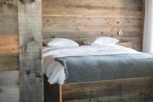 - une chambre avec un lit et un mur en bois dans l'établissement Aïda Hôtel & Spa - "Adults Only" Relais & Châteaux, à Crans-Montana