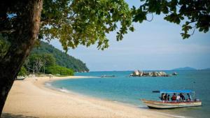 a boat on a beach with people on it at Pangkor Better Life Cozy Studio-walking 2min to beach,1-4pax in Pangkor
