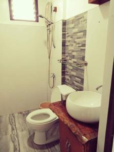 a bathroom with a white toilet and a sink at Dreamland Nilo Eve Beach Guest Huaz in El Nido