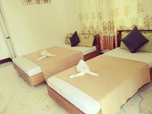 two beds in a small room with slippers on them at Dreamland Nilo Eve Beach Guest Huaz in El Nido