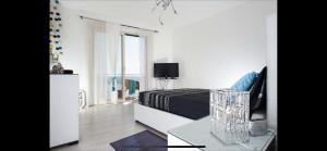 1 dormitorio blanco con 1 cama y TV en Beach Penthouse Marisol 2Floors, central, en Letojanni